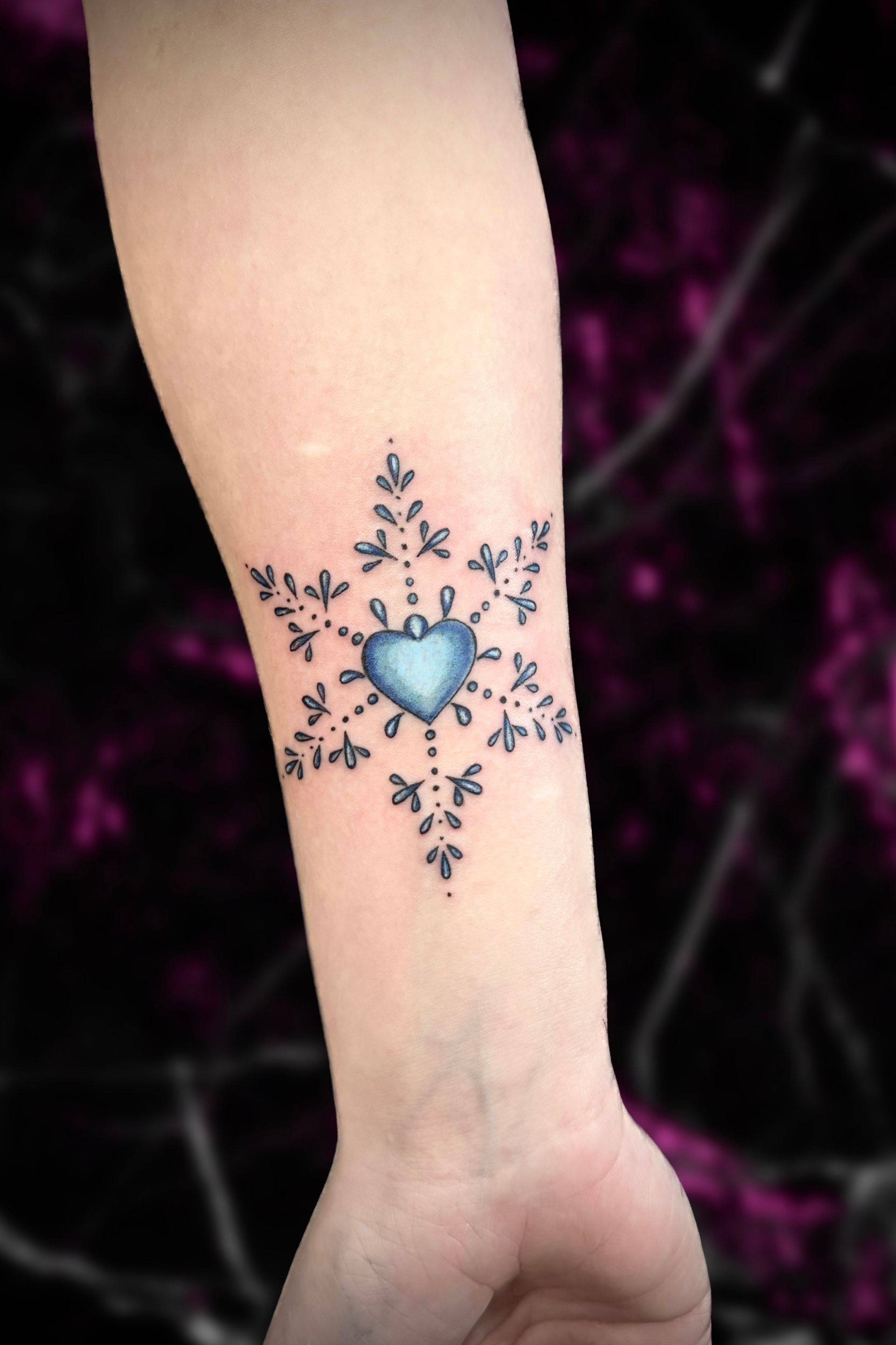 A woman has a snowflake tattoo on her wrist