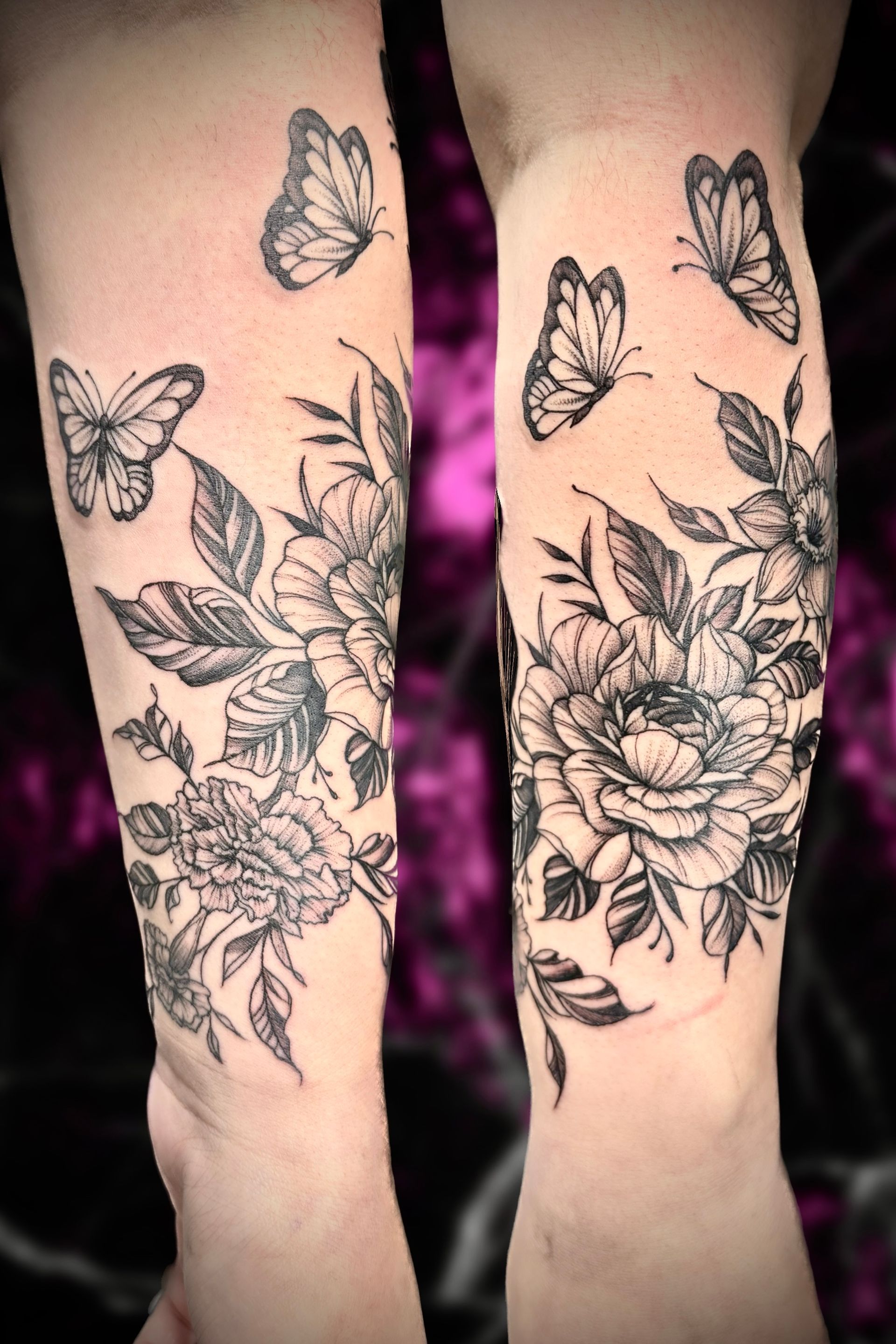 A woman has a tattoo of flowers and butterflies on her forearm