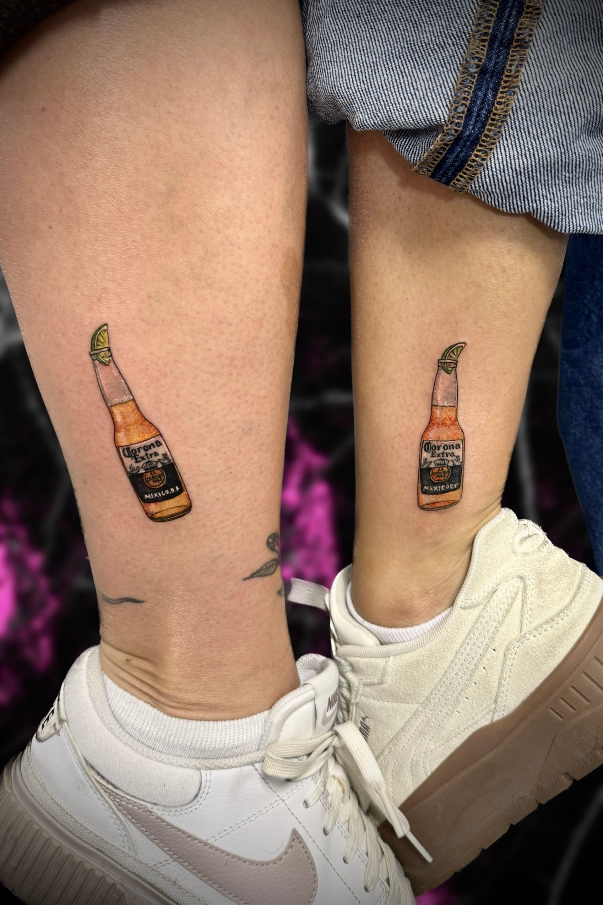 Two bottles of beer are tattooed on the ankles of two people