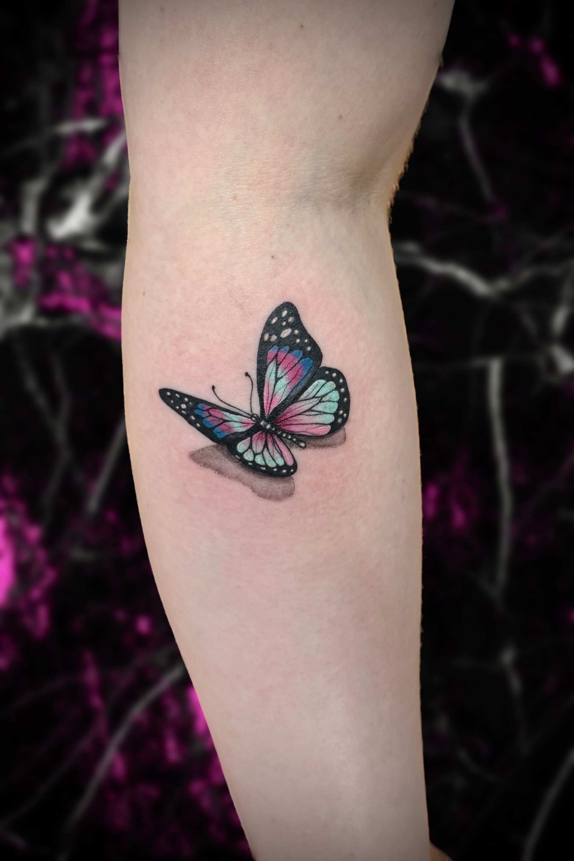 A woman has a small butterfly tattoo on her leg