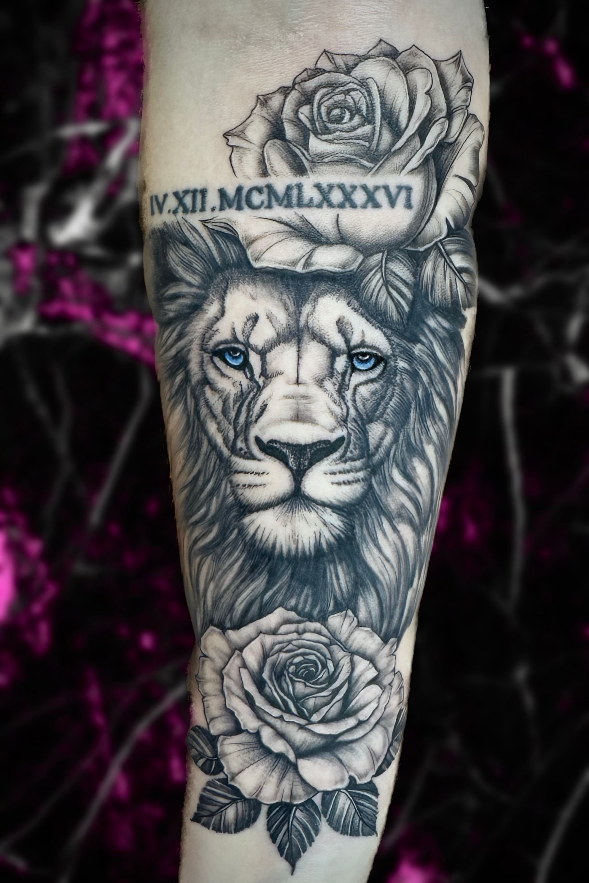 A black and white tattoo of a lion and roses on a persons leg