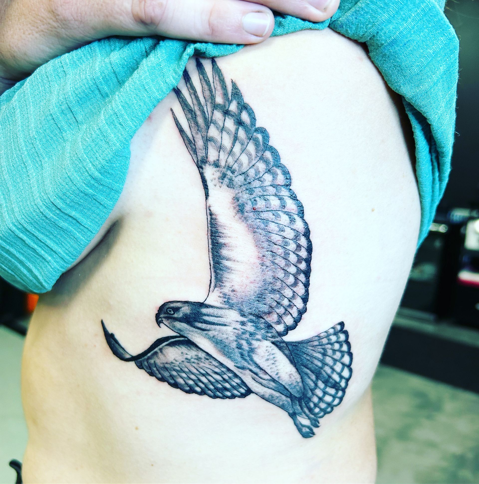A woman has a tattoo of an eagle on her side