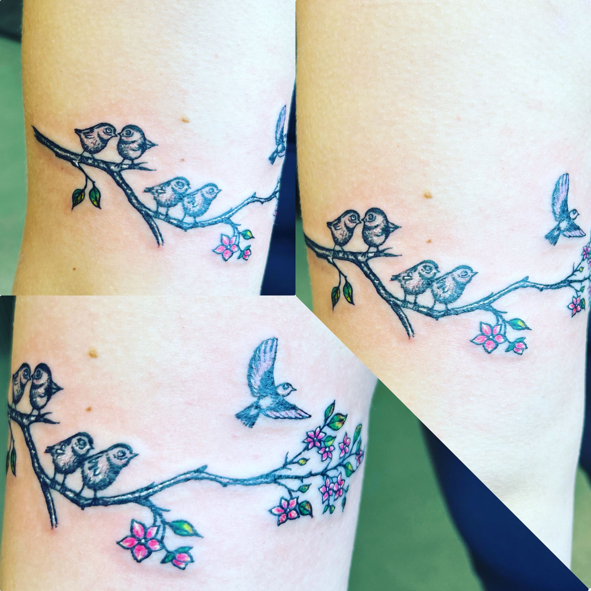A tattoo of birds sitting on a branch with flowers