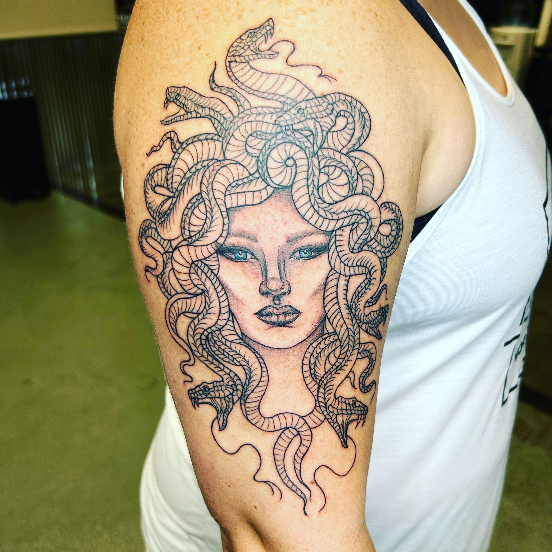 A woman has a medusa tattoo on her arm