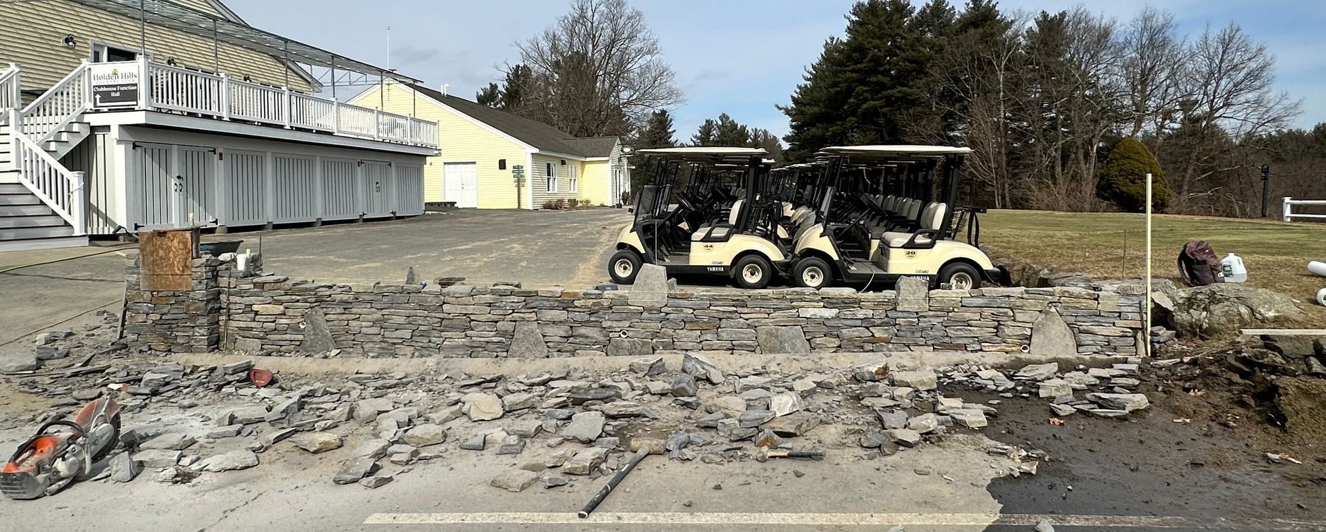 Damage from a fire at a building, with debris scattered and a utility vehicle in front