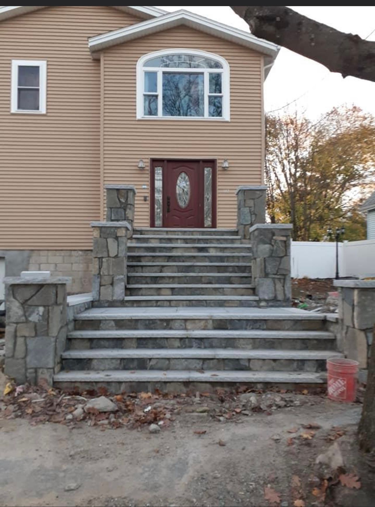 Front view of a house with wide stone steps leading to a red double front door