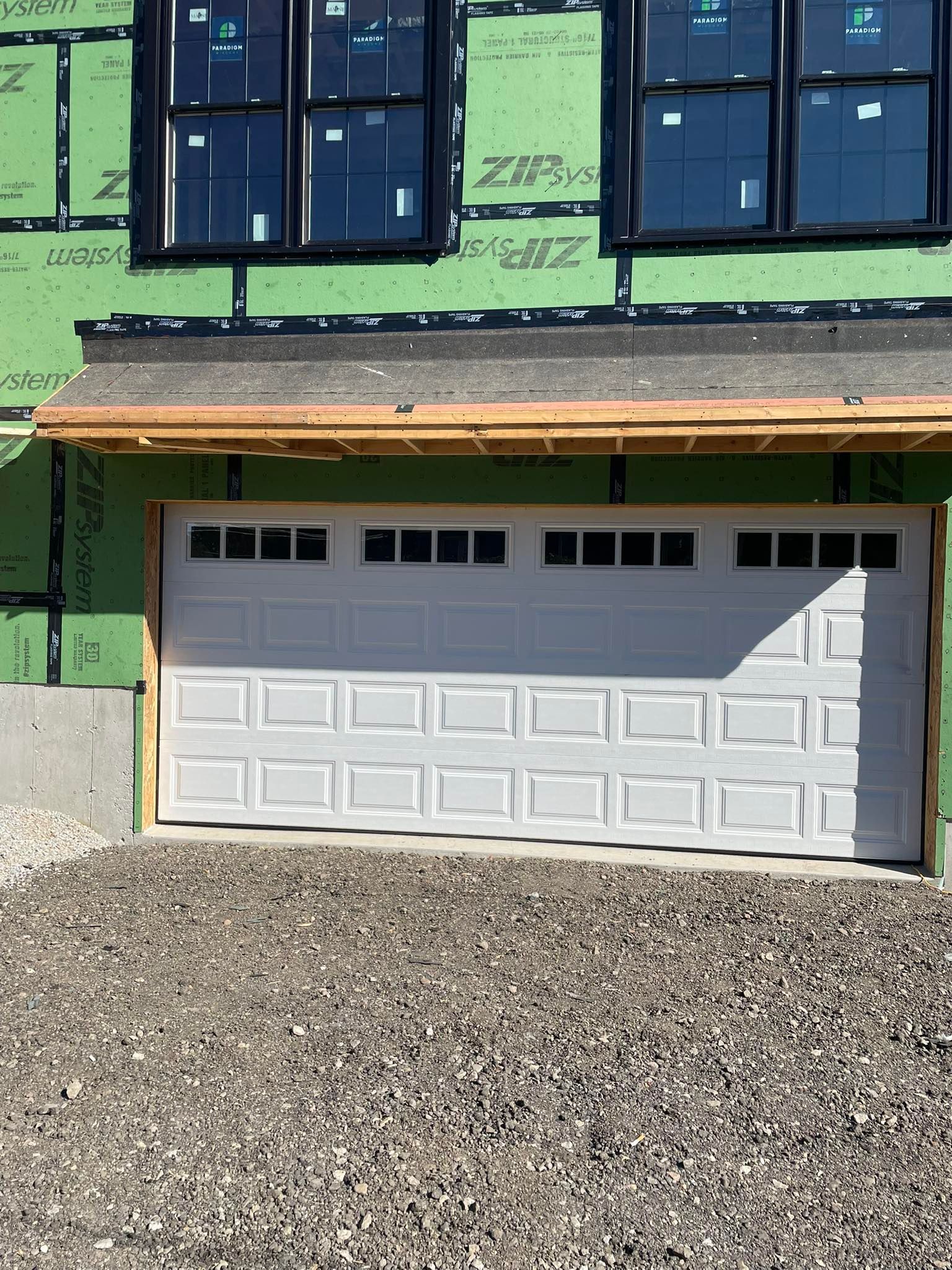 White garage door under construction, with windows above.