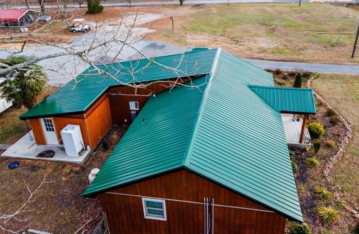 Green metal roof on a brown wooden building; outdoor setting.