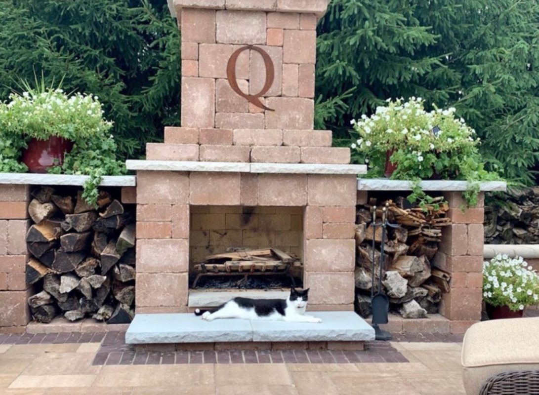 A brick fireplace with the letter q on it
