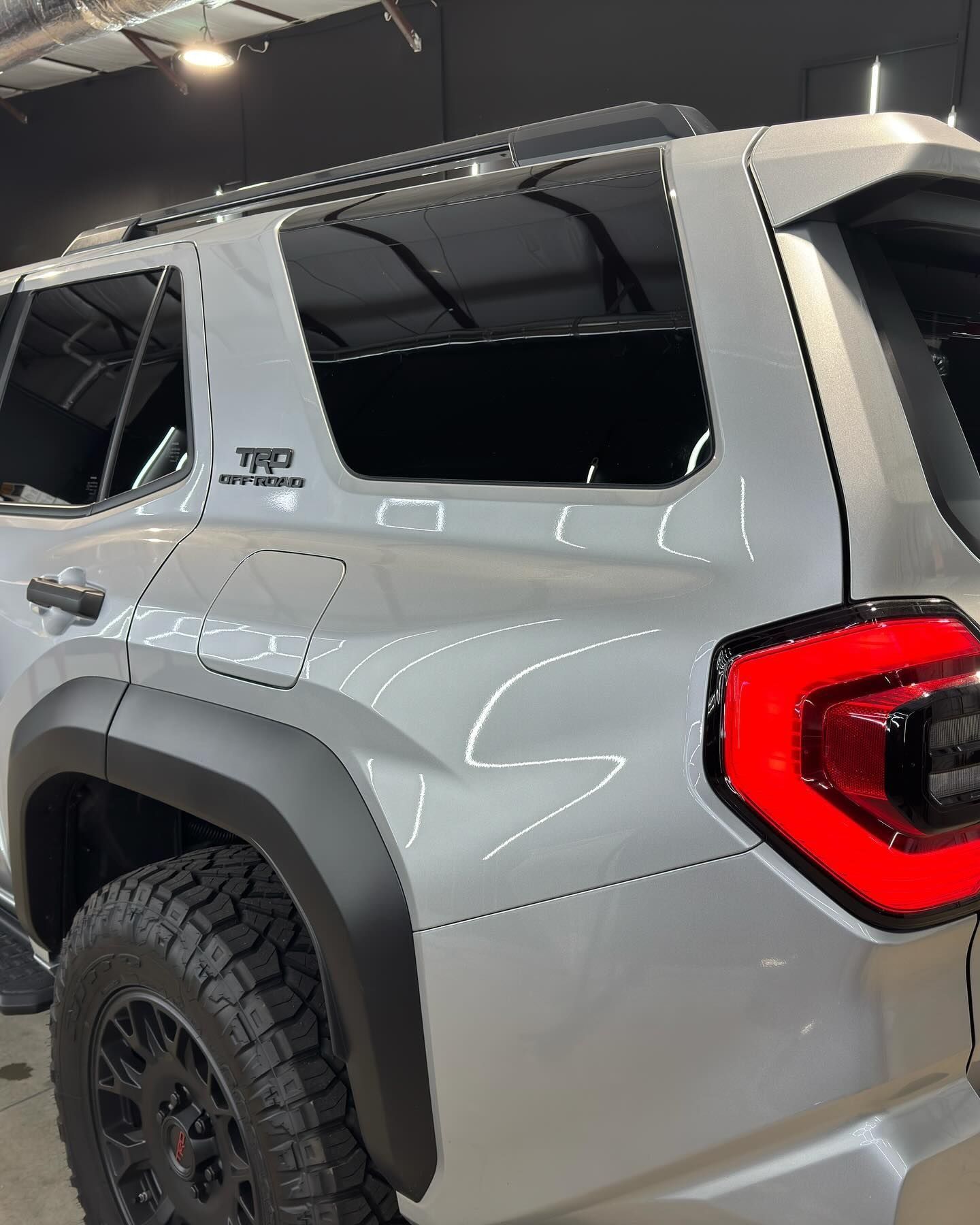 Silver SUV with black accents and a TRD Pro badge, parked indoors.