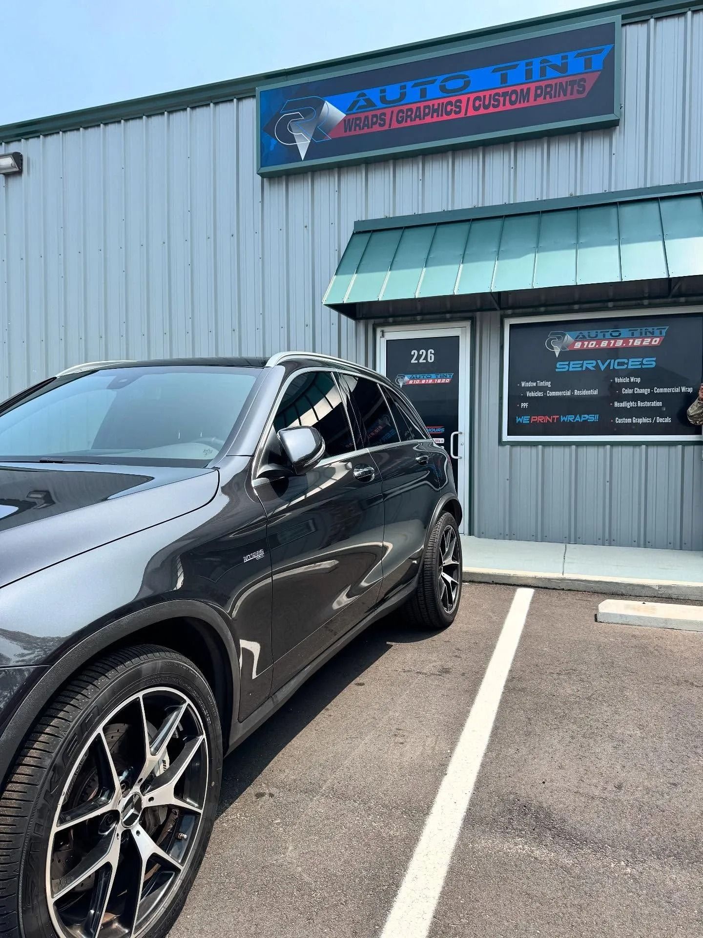 Gray SUV parked in front of Autospot Performance Center building.