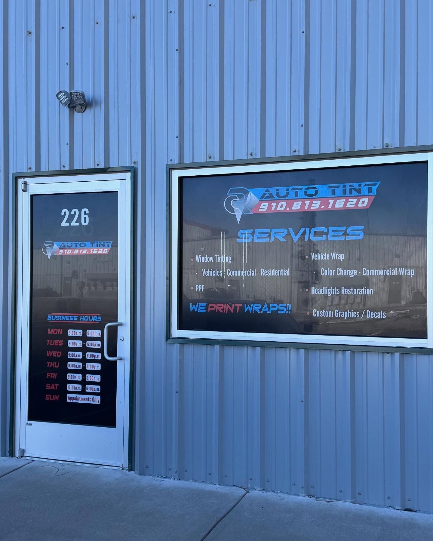 Exterior of Auto Tint Services shop with hours posted on the door.