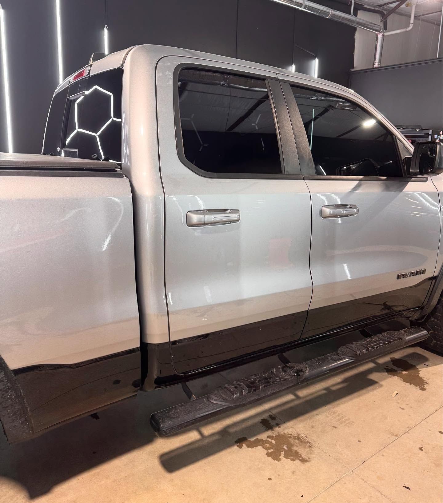 Silver and black pickup truck with tinted windows.