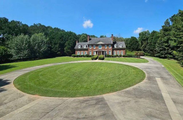 a large brick house with a circular driveway in front of it