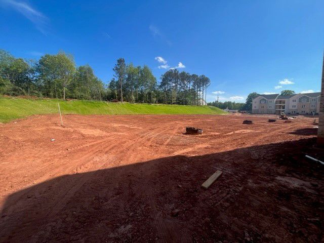 a dirt field with a building in the background