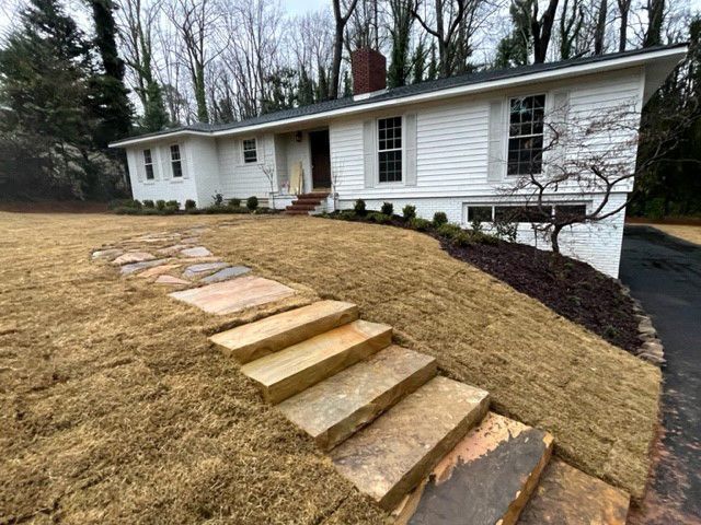 a white house with a stone walkway leading to it