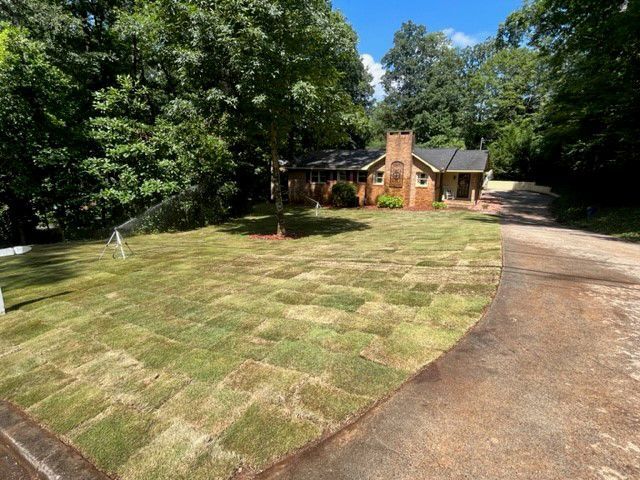 a house with a lush green lawn in front of it .