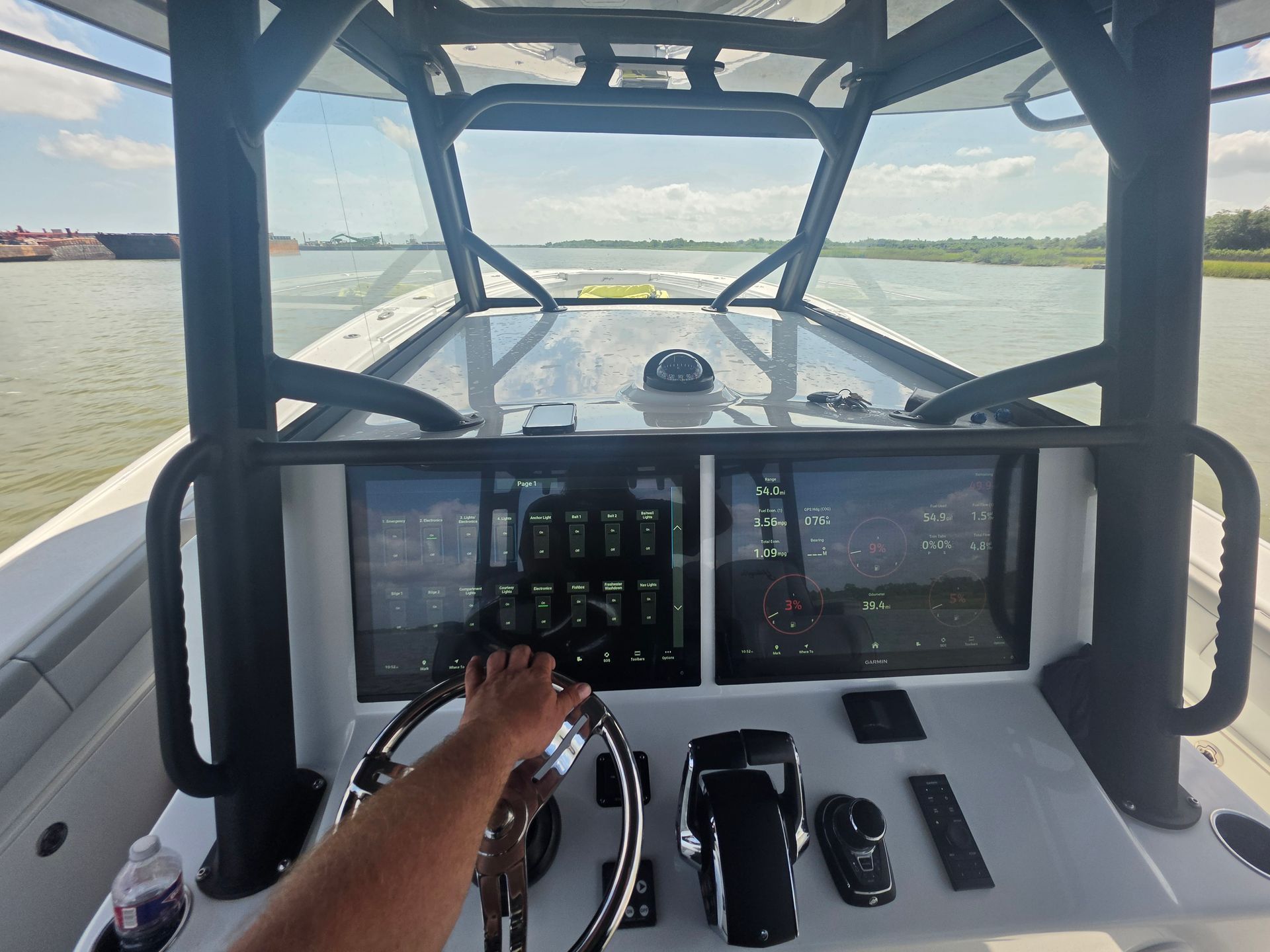 Steering a boat from the helm, with twin screens and open water ahead