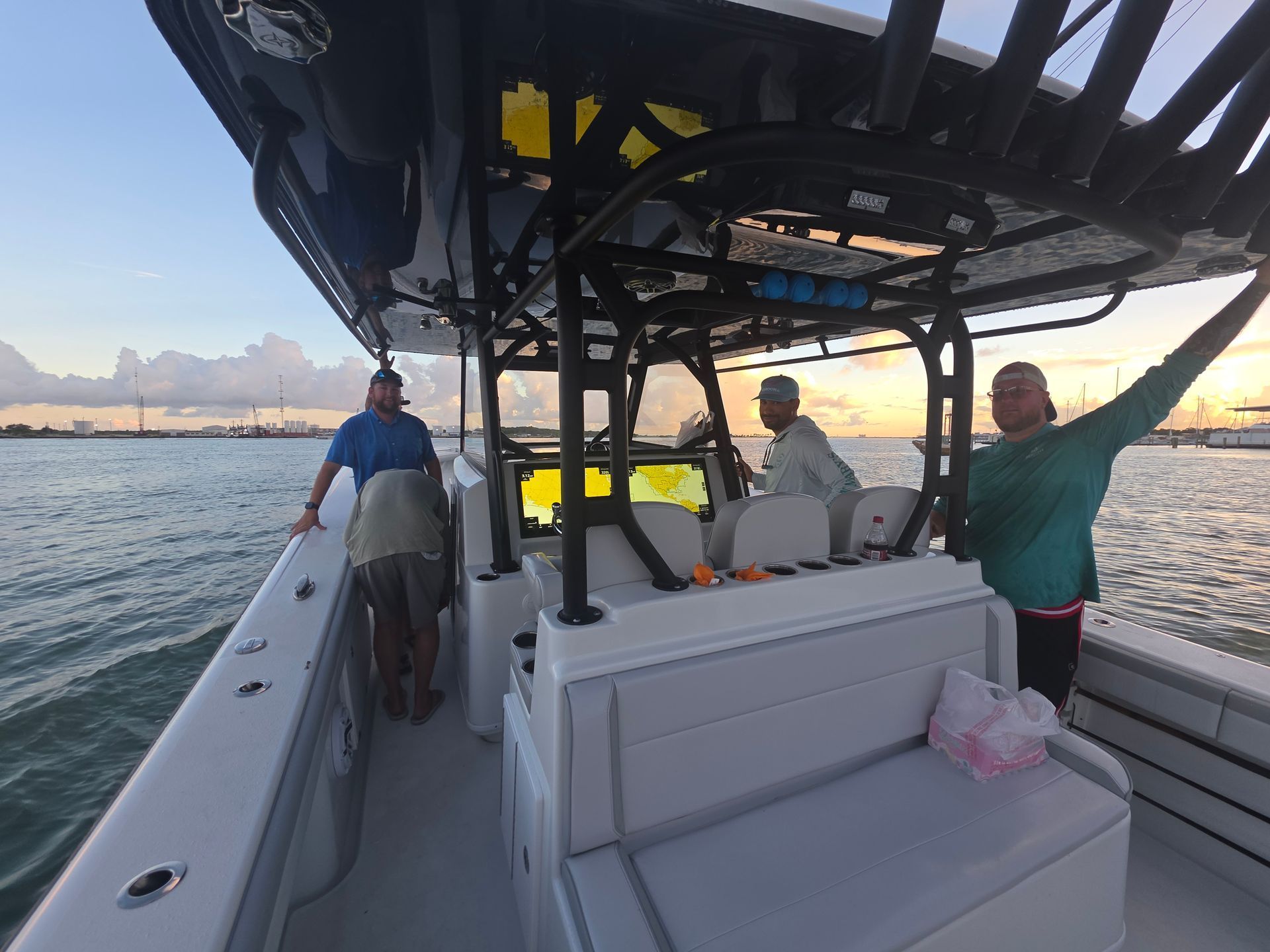 People on a boat at sunset, with ocean and distant mountains in the background