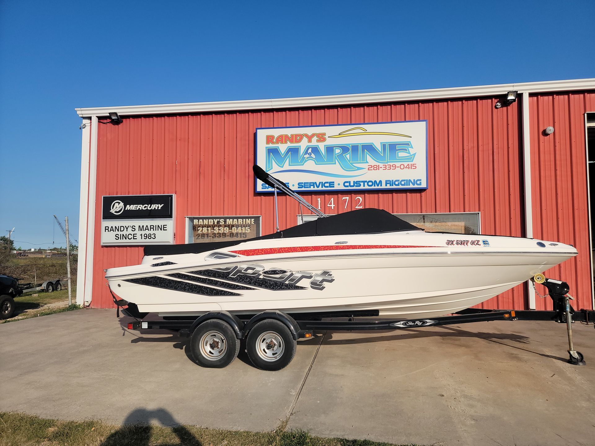 White boat with black and red graphics on a trailer in front of