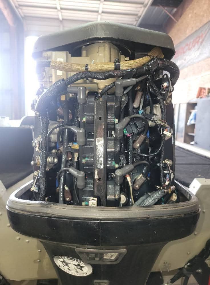 Outboard boat motor, dark gray, with visible wires and electrical components.