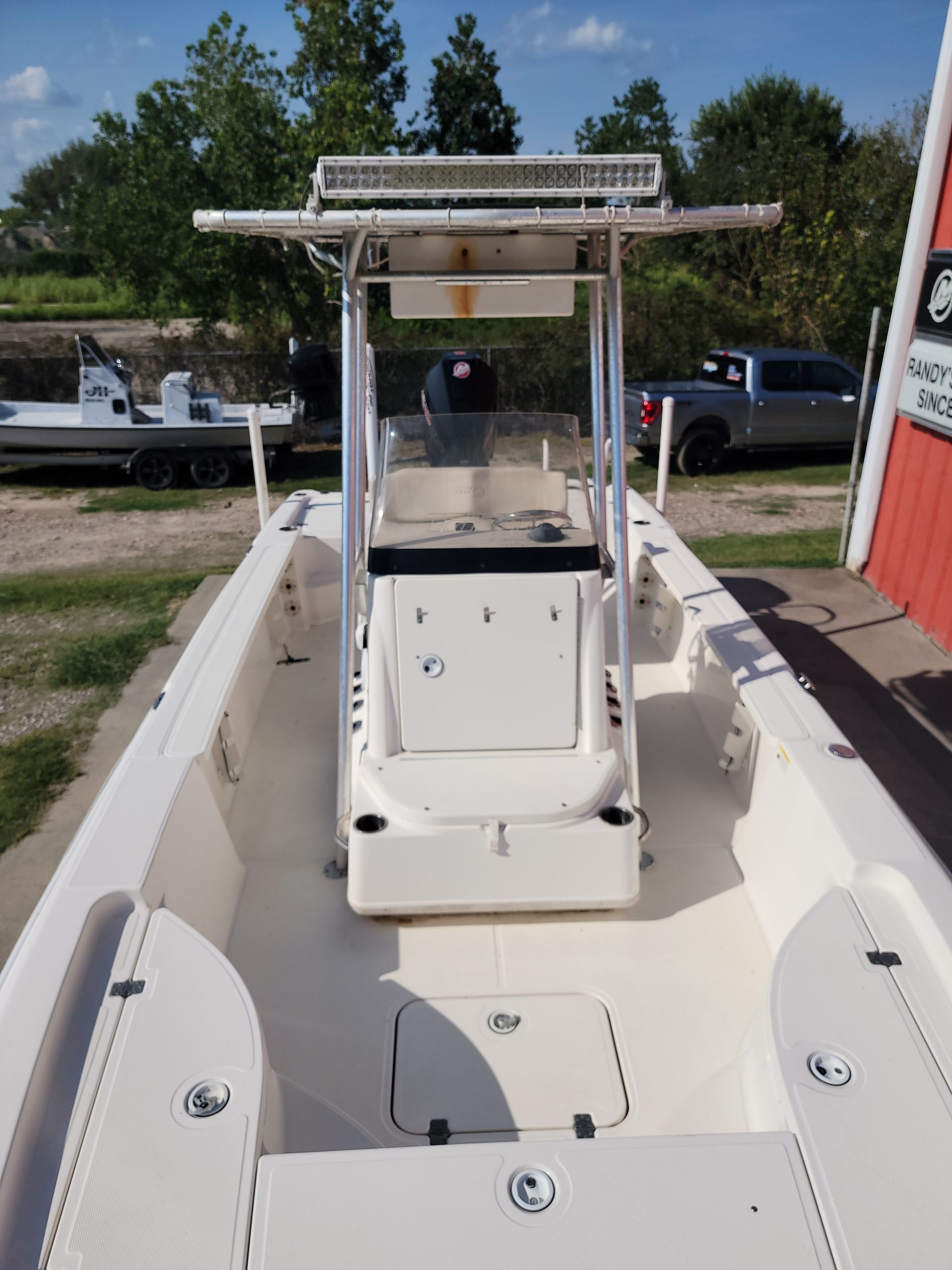 White fishing boat on land with a center console.