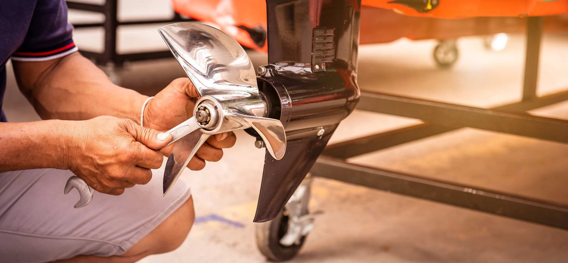 Person using a wrench to repair a boat propeller.