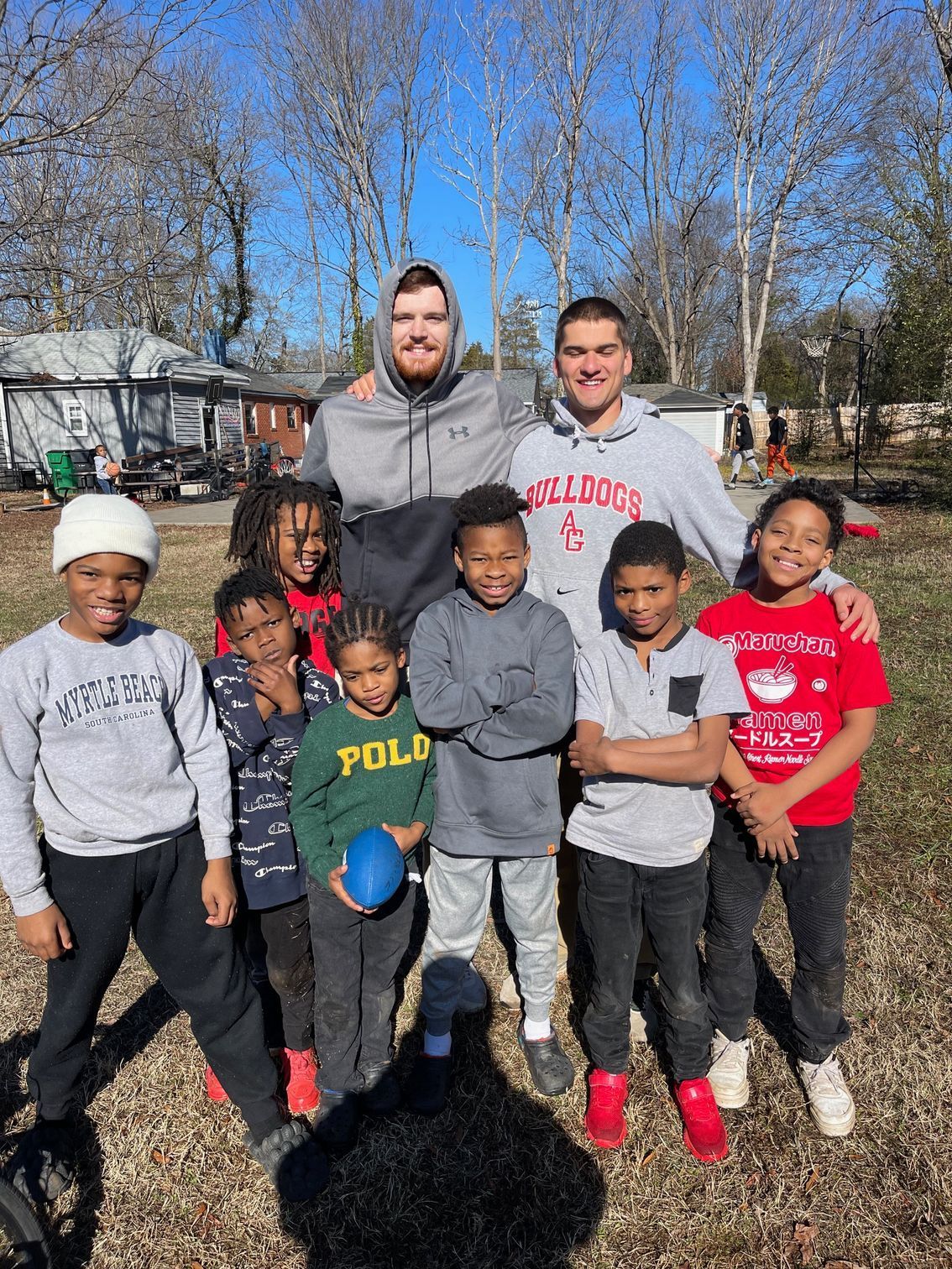 Two men and seven boys posing for an outdoor group photo