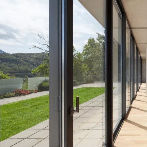 A long hallway with a lot of windows leading to a patio