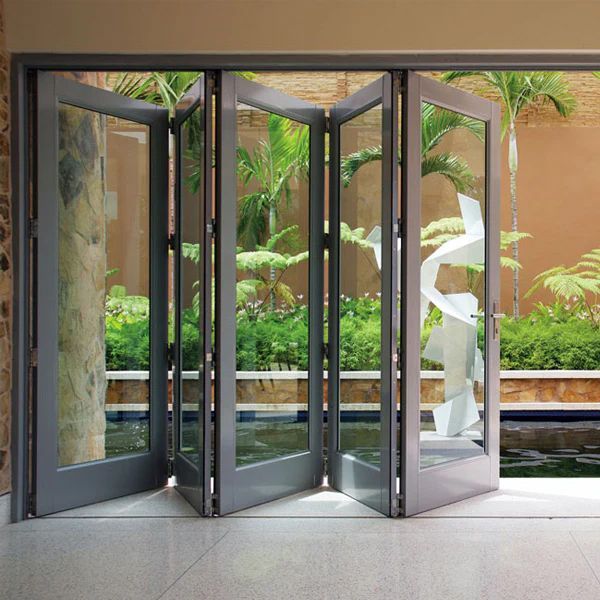 A room with a lot of glass doors leading to a garden