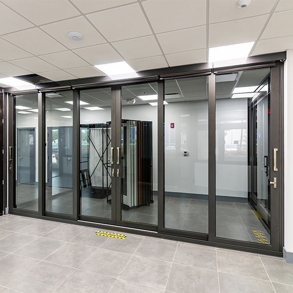 A room with a lot of glass doors and a yellow sign on the floor.