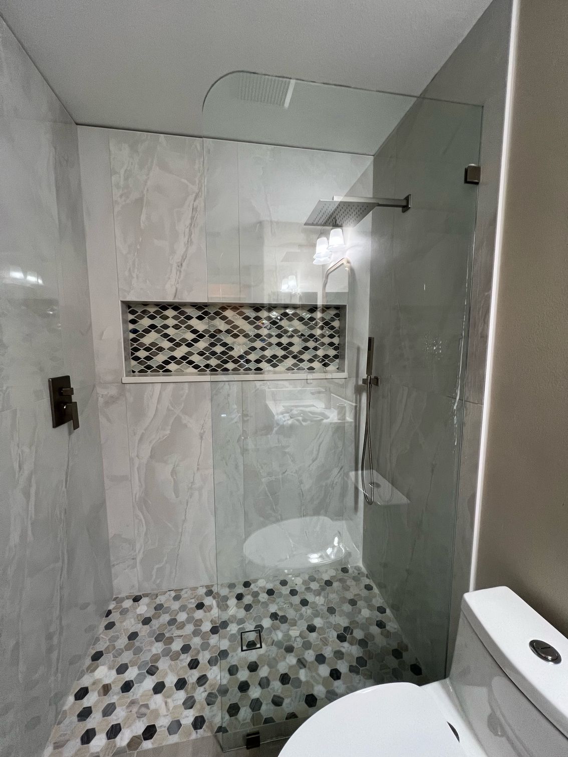 A bathroom with a walk in shower and a toilet.