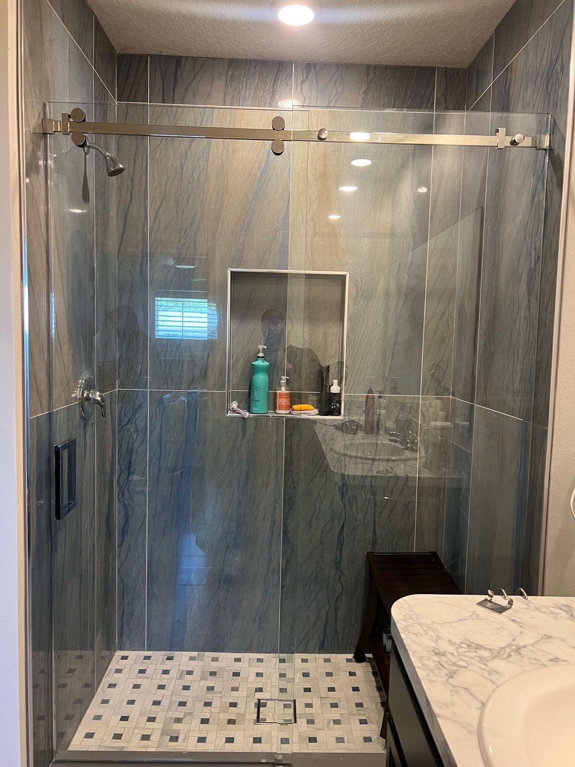 A bathroom with a sliding glass shower door and a sink.