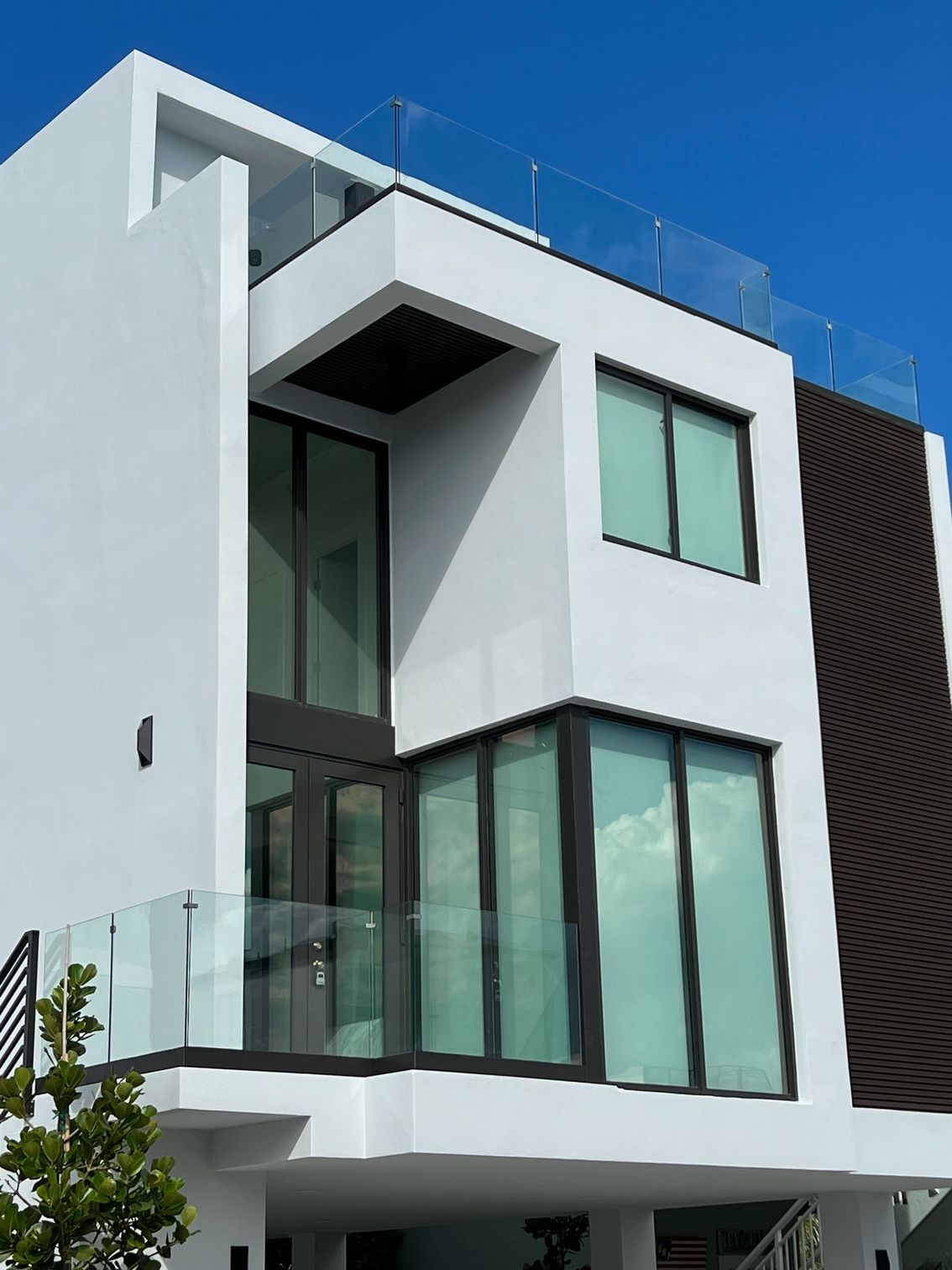 A white house with a balcony and a blue sky in the background