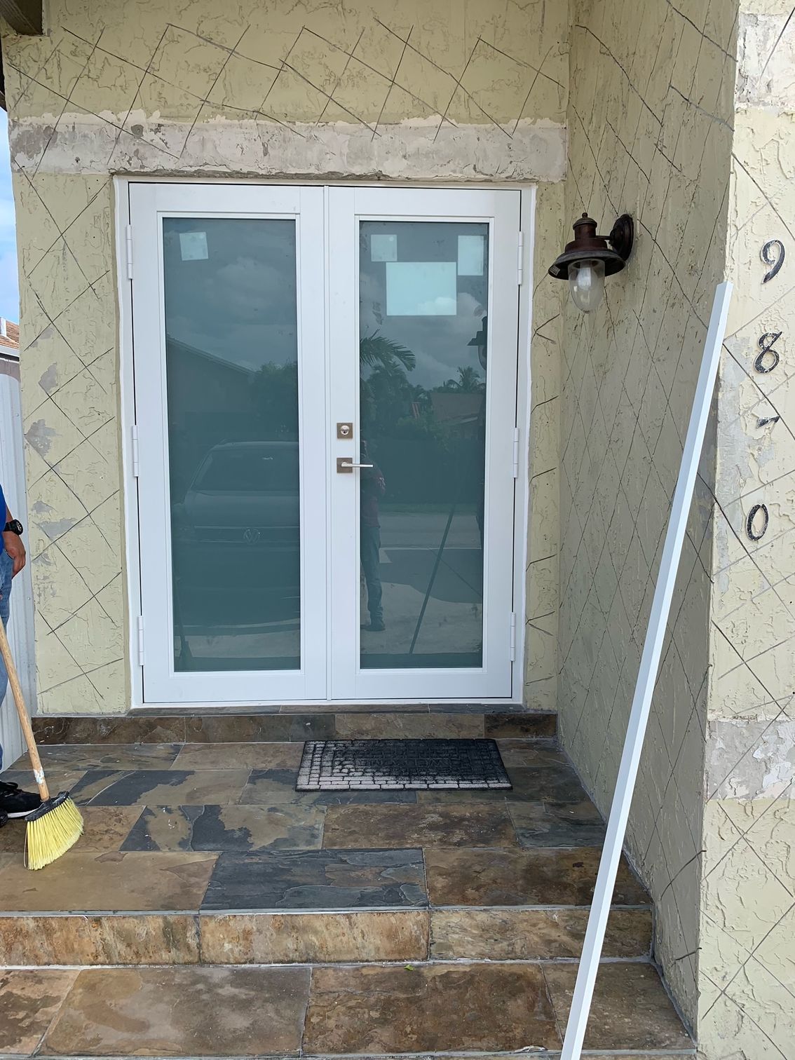 A man is sweeping the steps of a house with a broom