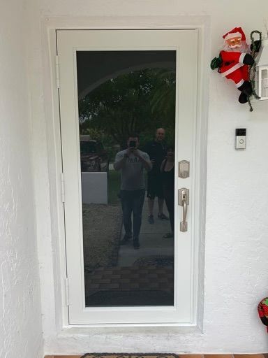A man is taking a picture of his reflection in a door.