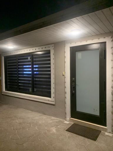 A house with a black door and windows at night.