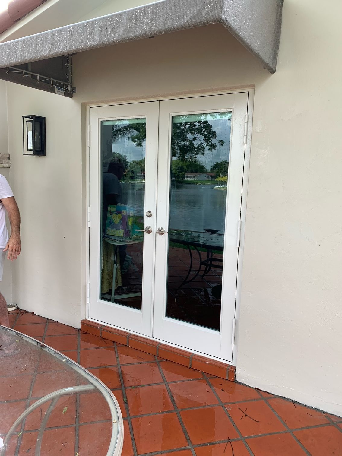 A man is standing in front of a door with a canopy over it.