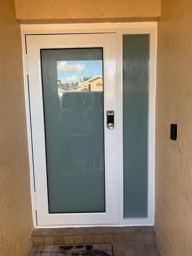 A white door with a glass panel on the side of it.