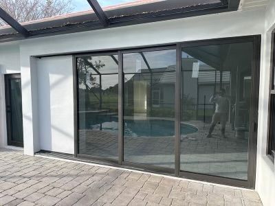 A large sliding glass door leading to a swimming pool.