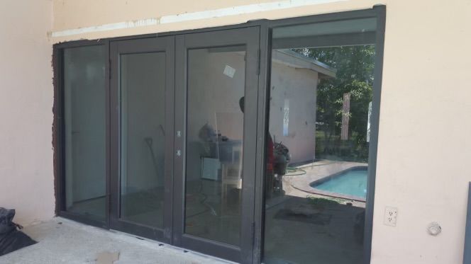 A patio with sliding glass doors leading to a pool.