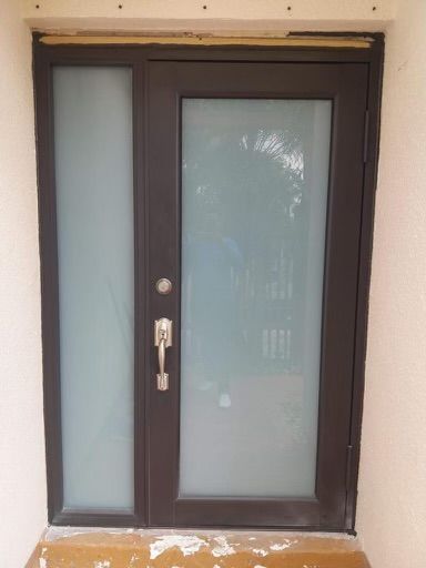 A black door with a frosted glass window and a handle.