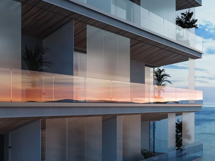 An artist 's impression of a building with a balcony overlooking the ocean.