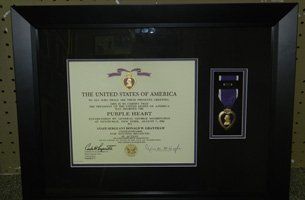 Two framed paintings of birds are sitting on a rug in a room