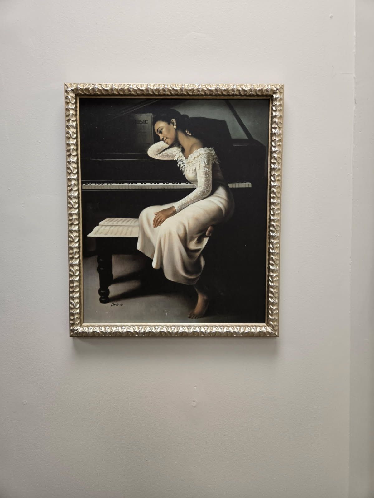 A framed painting of horses grazing in a field