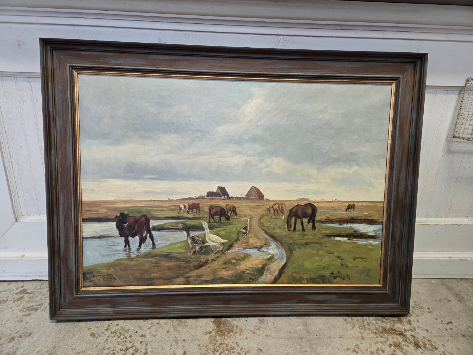 A framed painting of horses grazing in a field