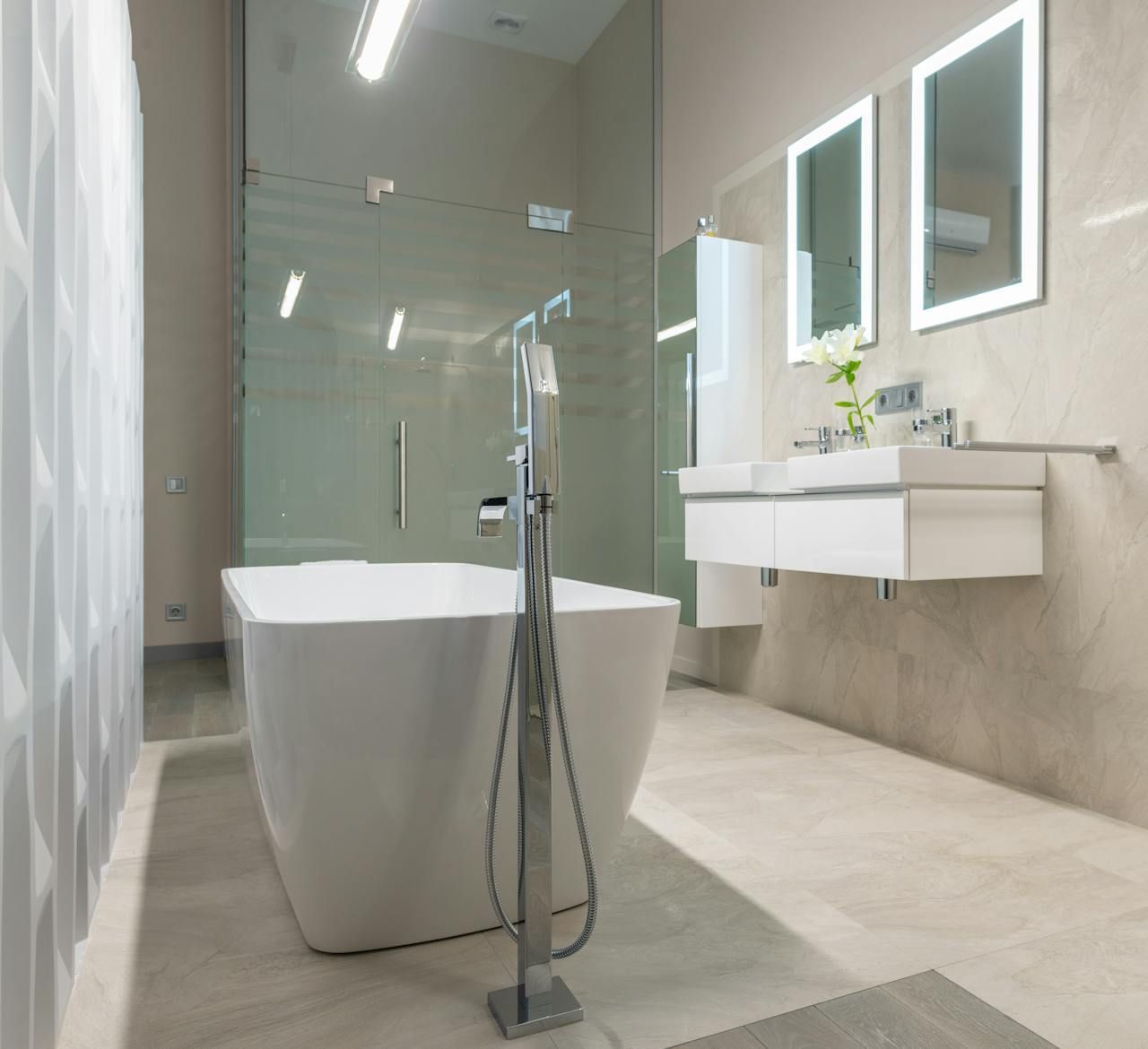 Modern bathroom with a freestanding tub, glass shower, floating vanity, and large mirrors