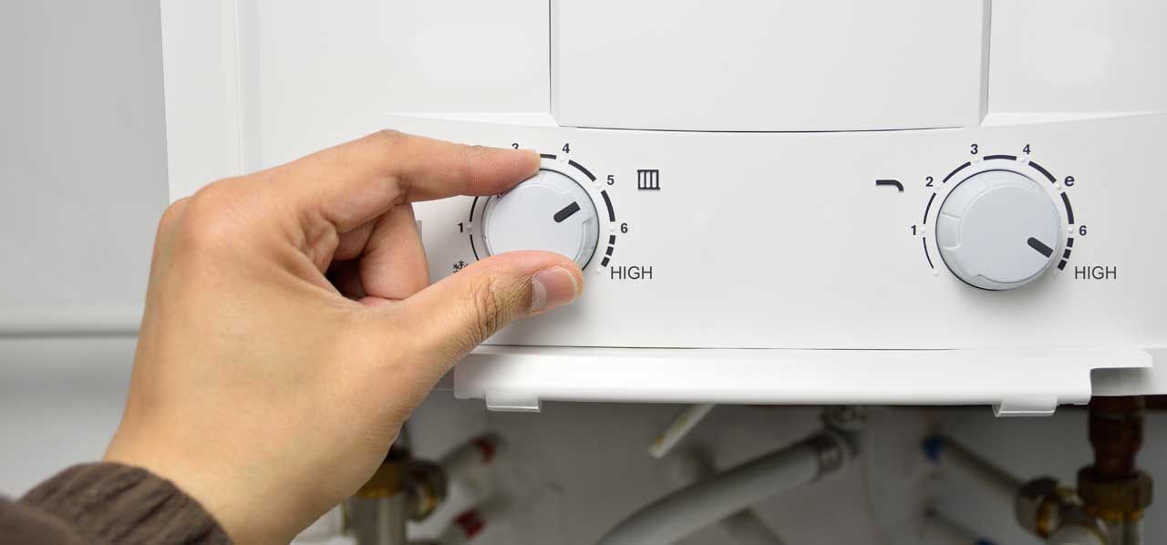 Hand turning a white appliance control knob on a stove or oven panel