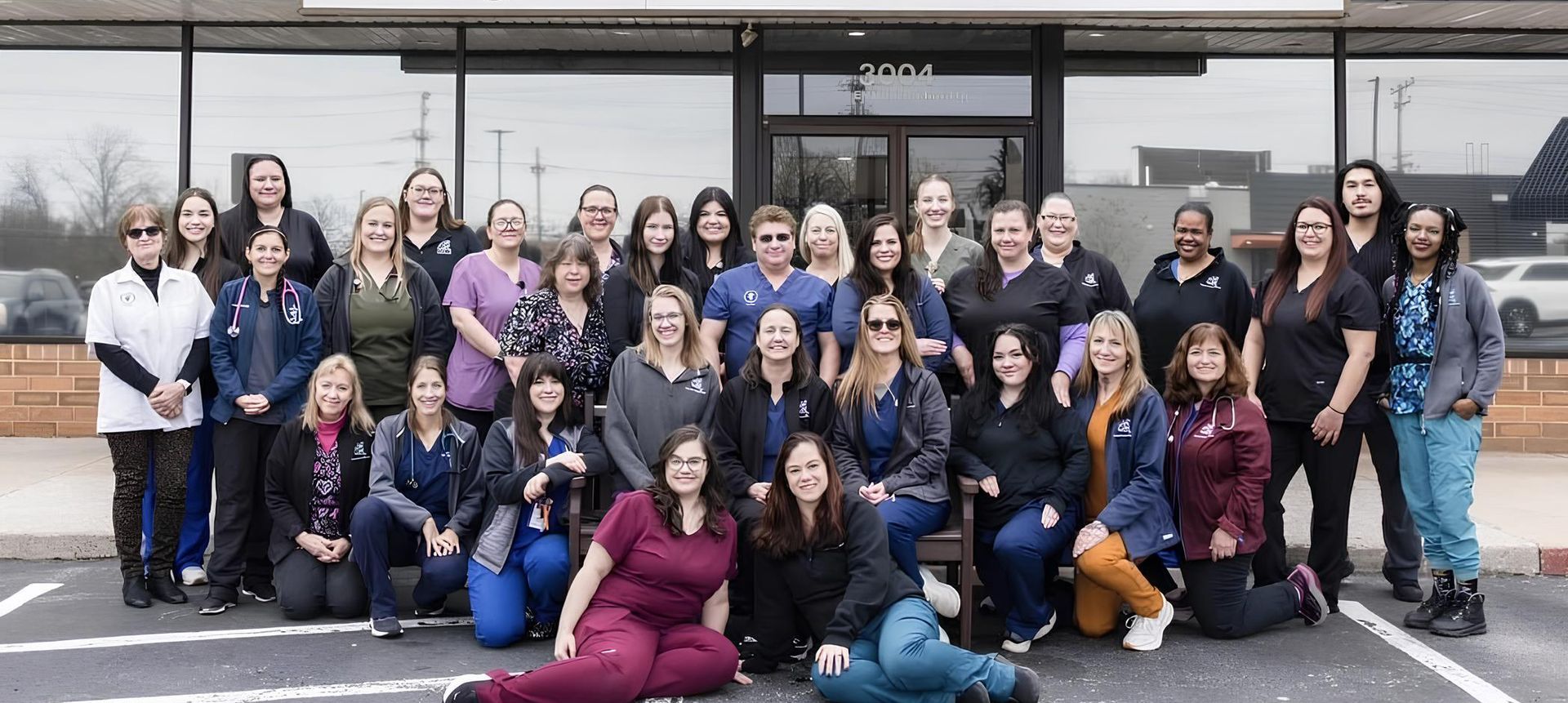 A large group of people are posing for a picture in front of a building.