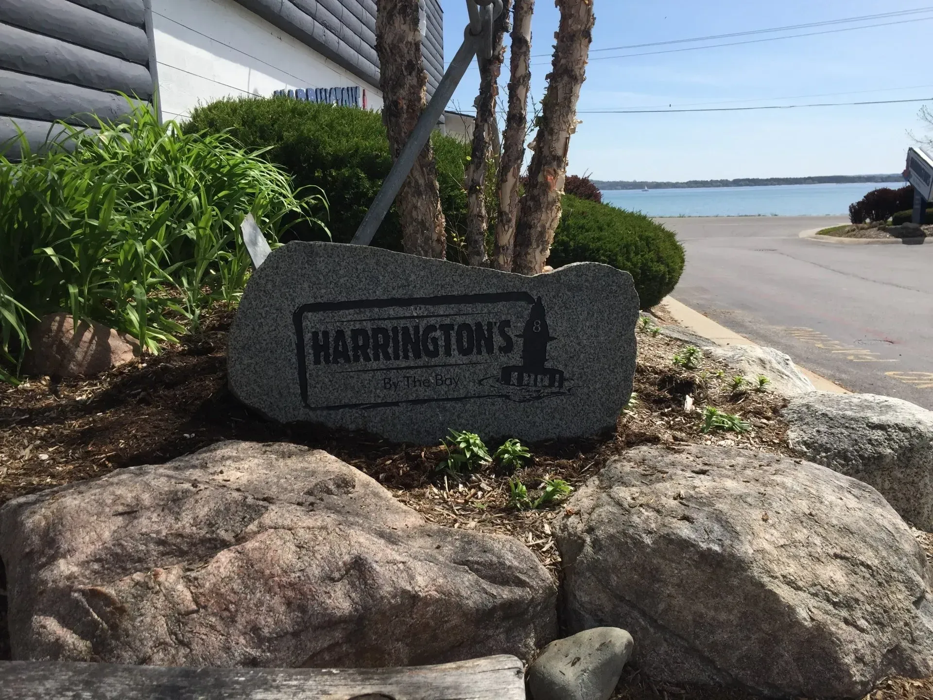 Harrington's sign on large rocks with water and sky in the background.